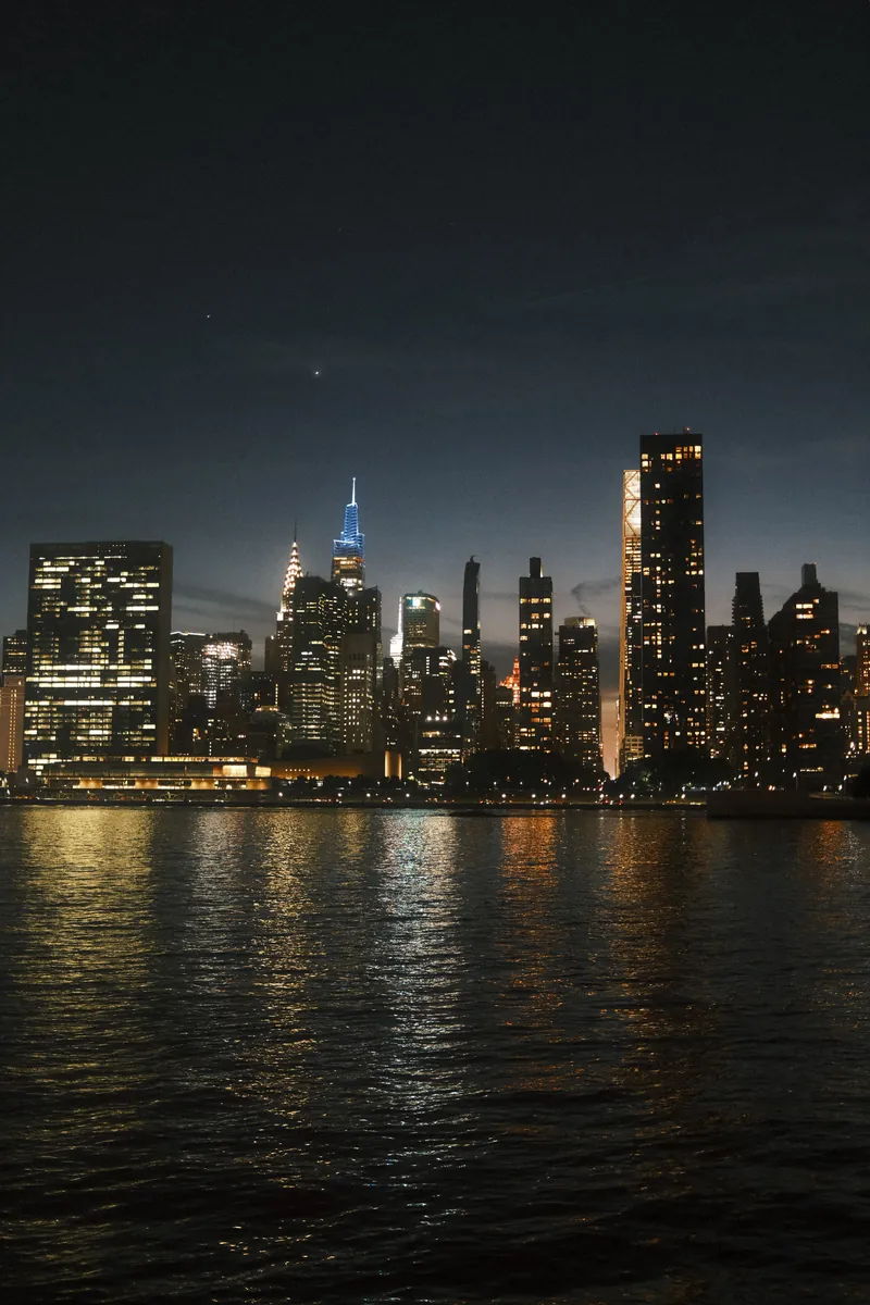 The Manhattan skyline at blue hour reflected in the East River